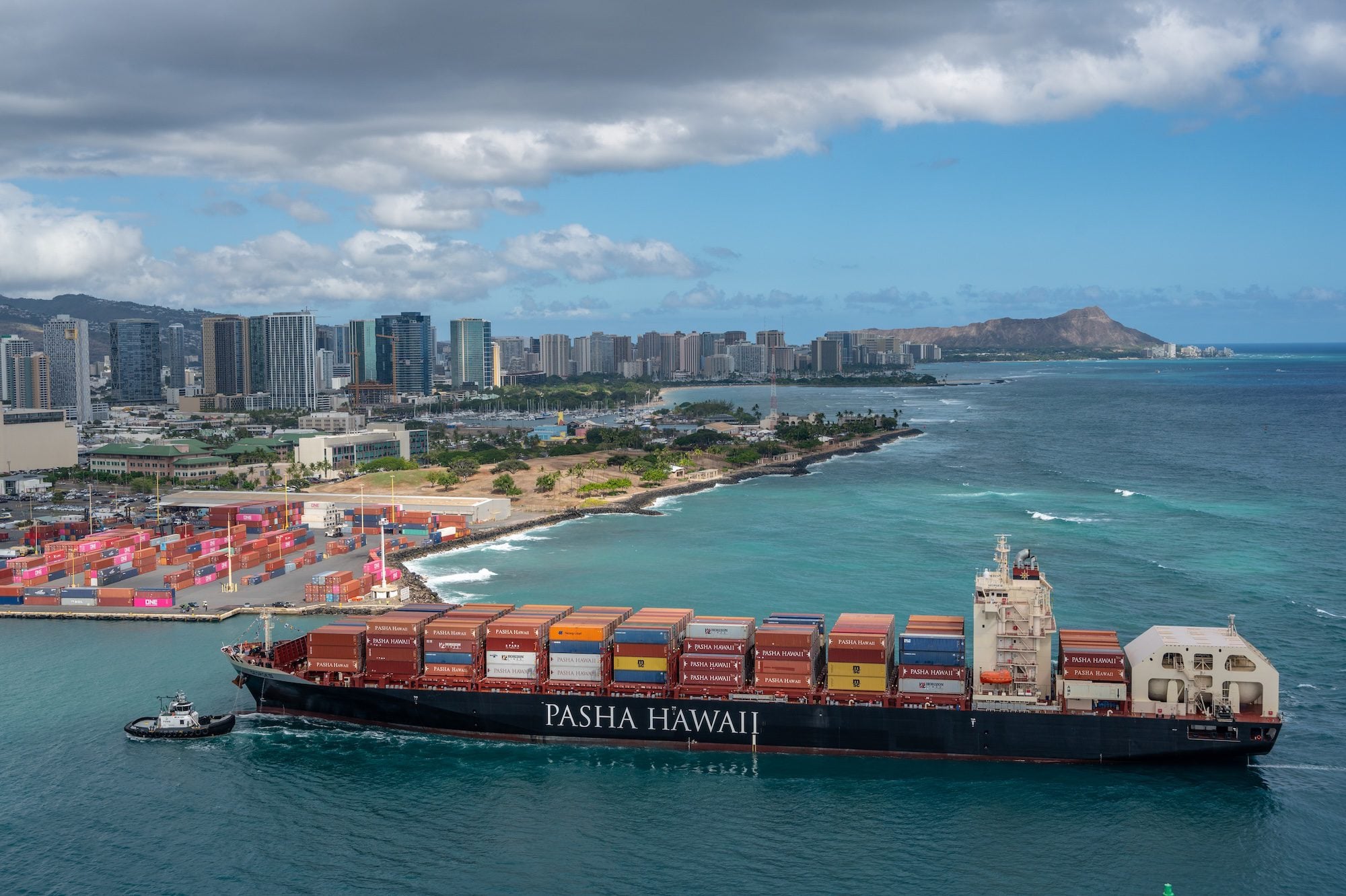 Pasha Hawaii containership George III arriving in Honolulu, Hawaii, with Diamond Head and the city skyline in the background.