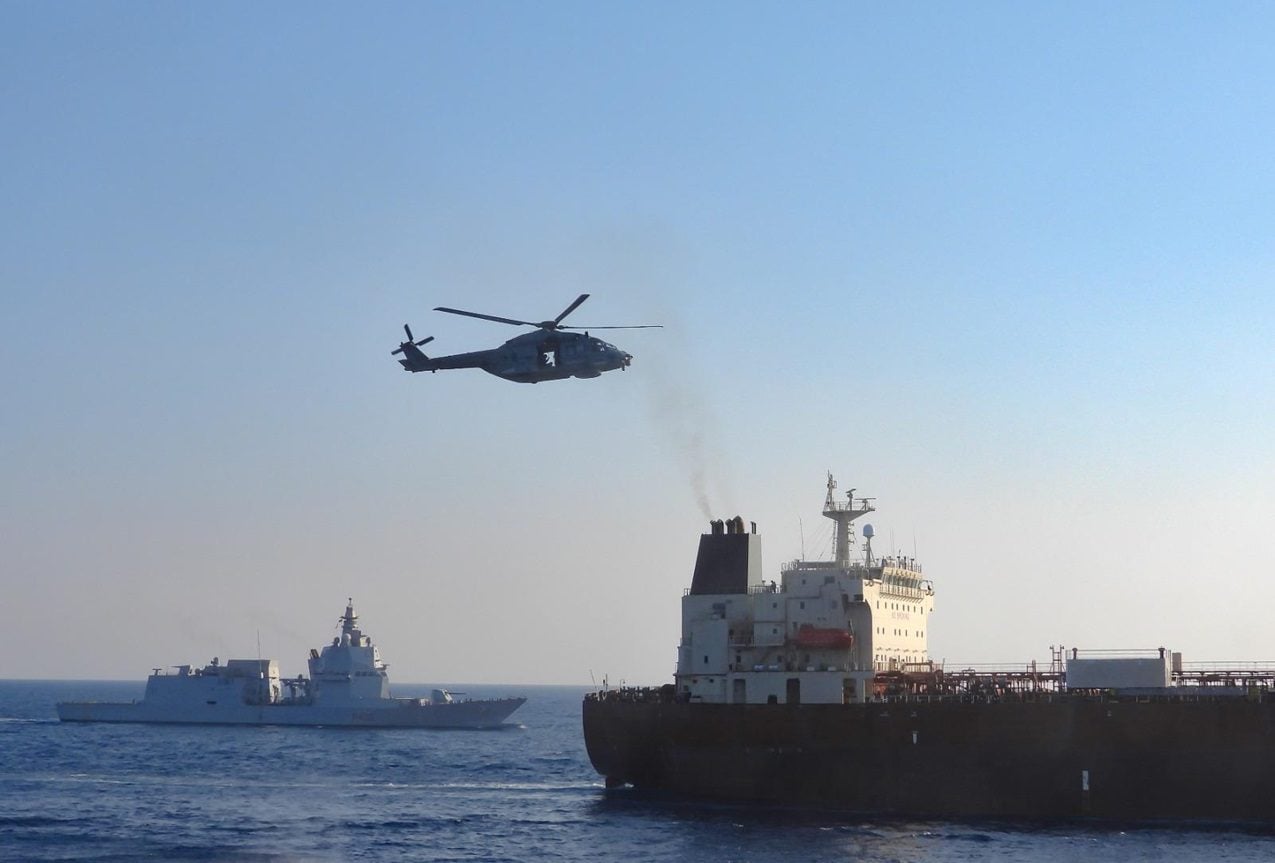An Italian Navy helicopter hovers over the sanctioned tanker Toa Payoh as ITS Thaon di Revel conducts a flag-verification boarding during an Operation IRINI mission in the Mediterranean.