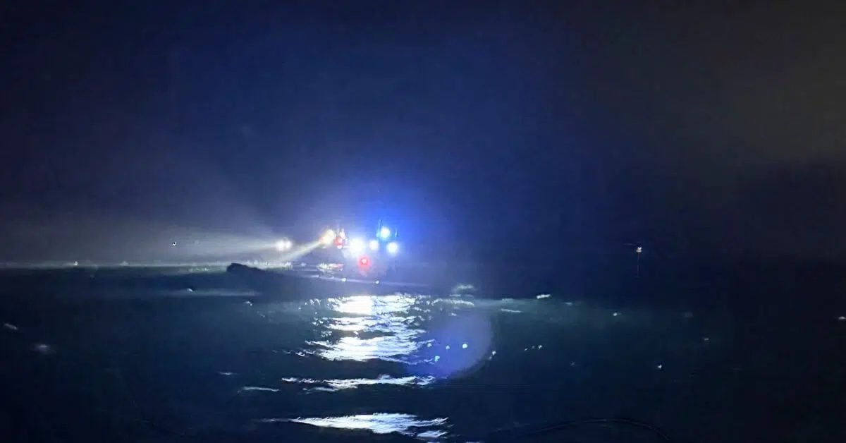 Rescue boats with flashing blue lights search the water at night near Tjörn, Sweden, after the fatal collision between the cargo ship Misje Verde and a pleasure boat.