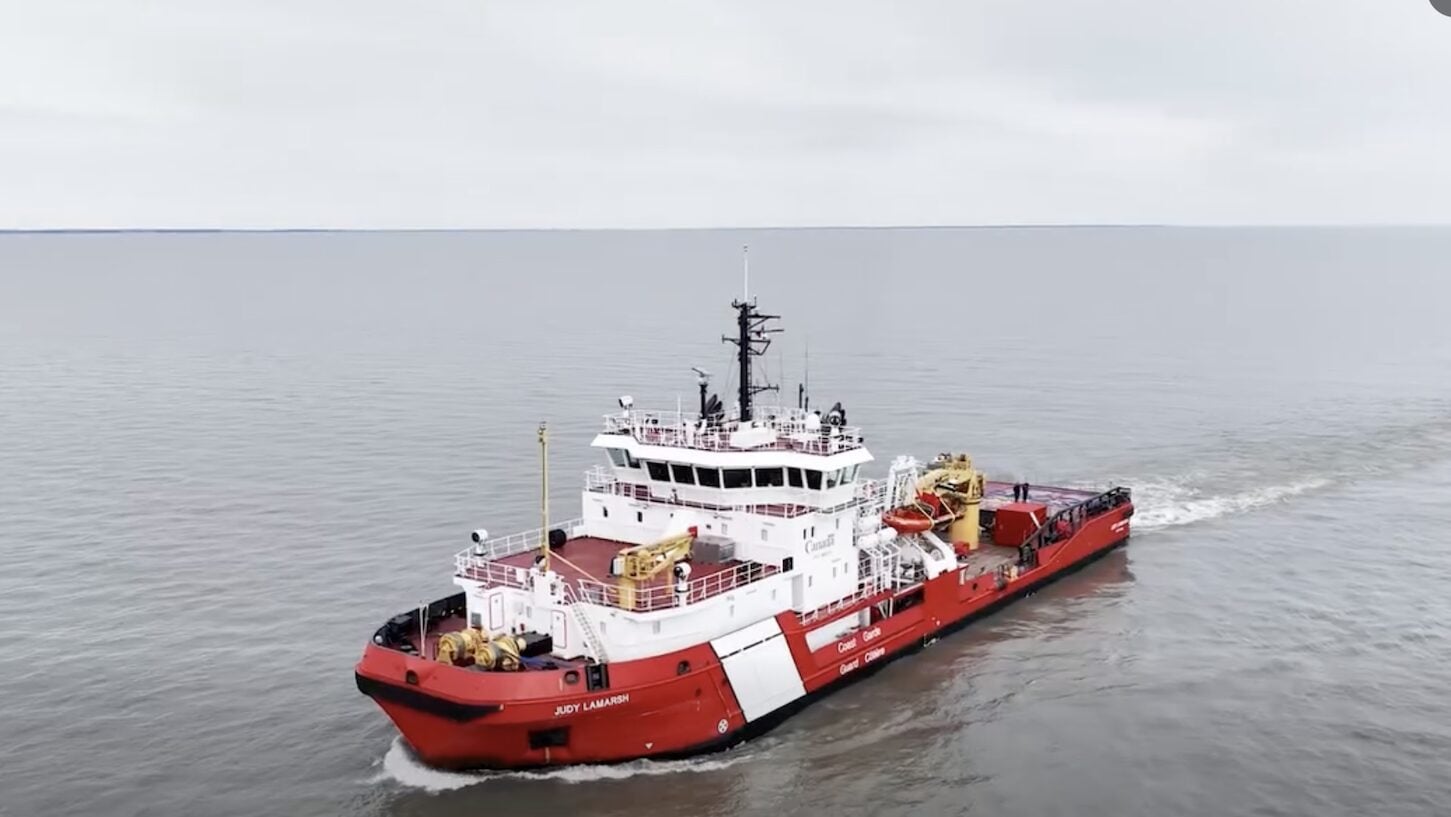 Canadian Coast Guard Ship Judy LaMarsh, a red-and-white light icebreaker, underway on calm waters of the Great Lakes.